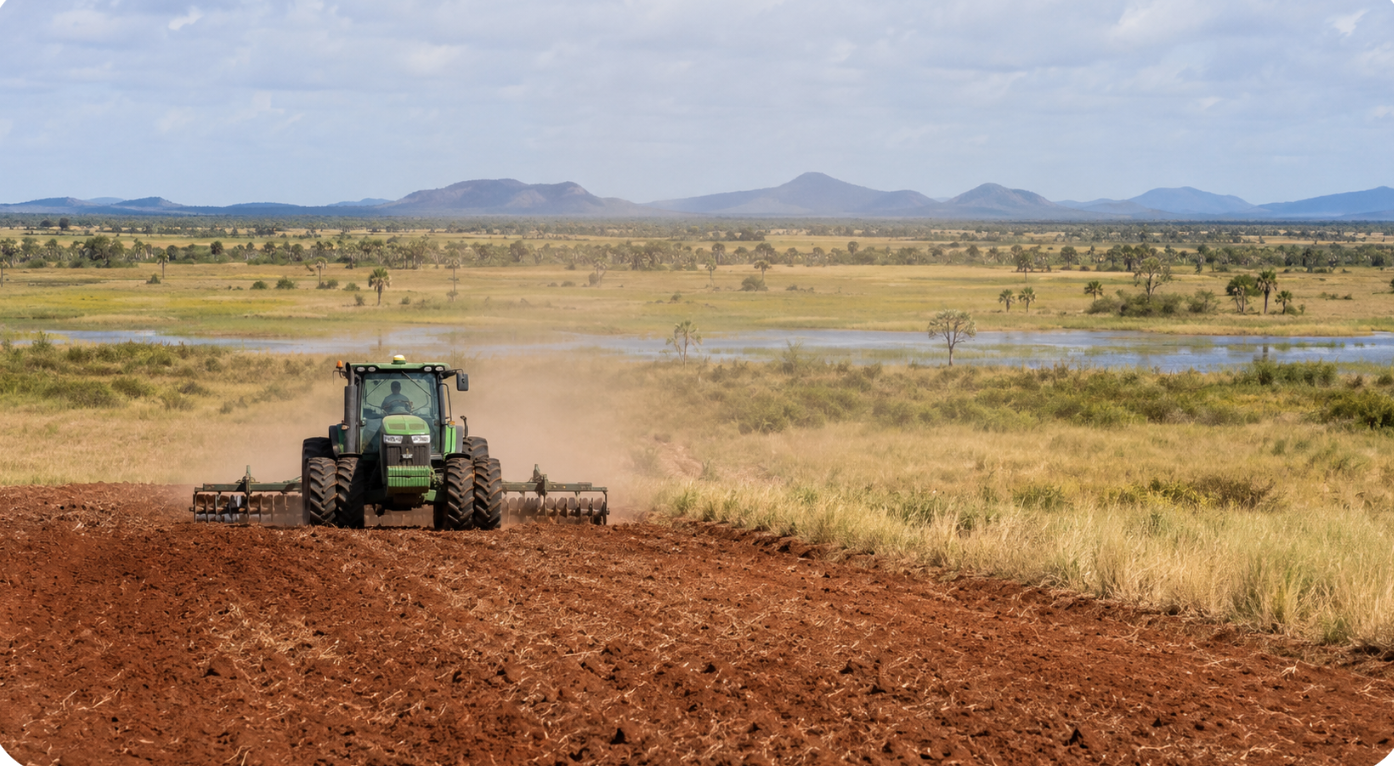 A mechanized tractor works a cleared savanna field at the edge of intact Rupununi wetland under morning light.